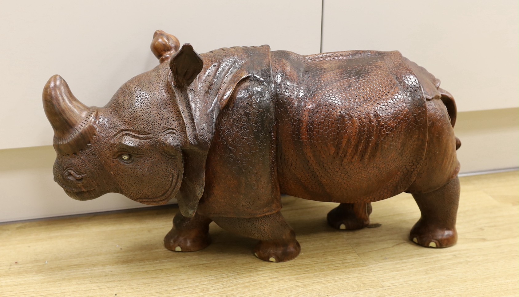 A carved wooden model of a rhinoceros, approximately 60cms long